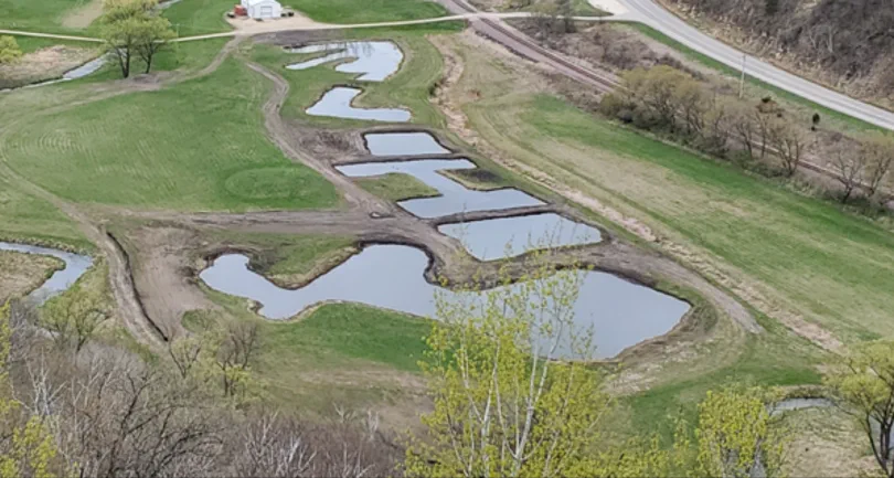 Overhead view of a long chain of shallow ponds and mown grass strips on a managed waterfowl property
